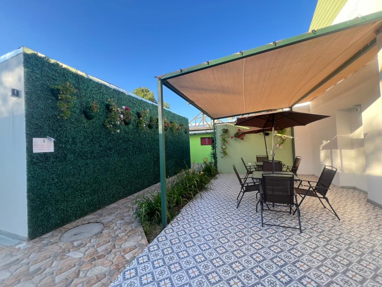 Terraza común con pérgola y muro verde